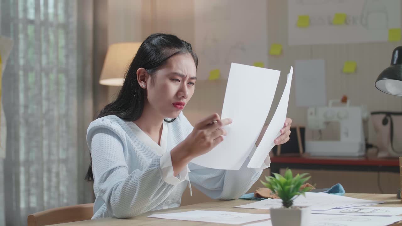 Upset Asian Woman Bag Designer Positively Shaking Her Head While Looking At The Layout Bond At The Office