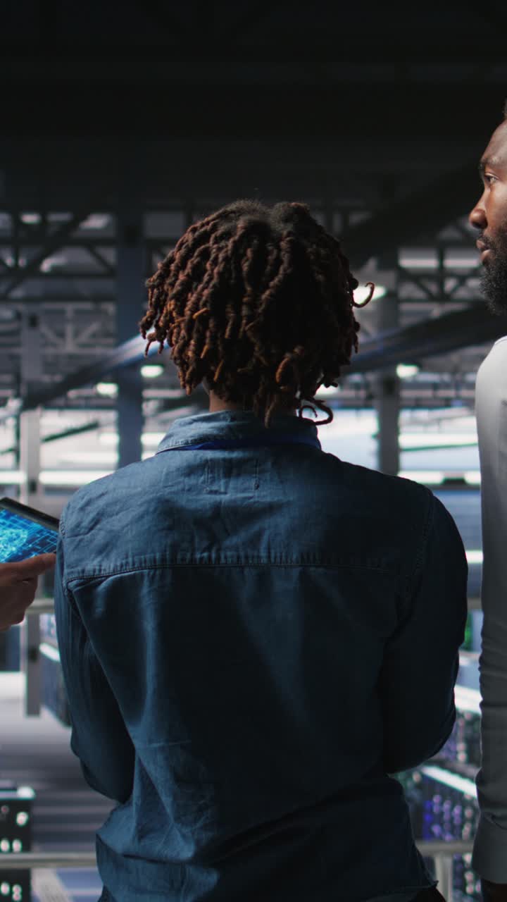 Vertical video Data center manager talking with workers doing maintenance on AI supercomputers