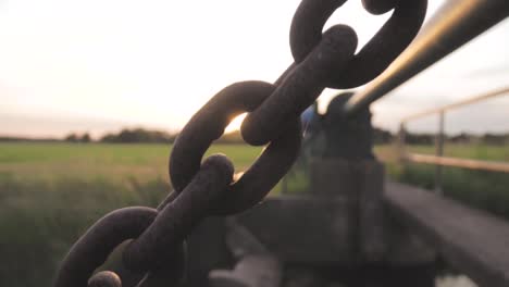 rusty chain link bridge in sunset