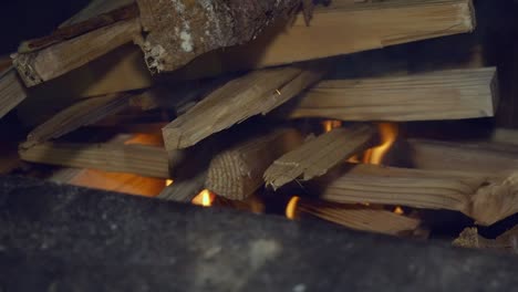 la leña seca cortada apilada en el fuego del campamento se desploma mientras arde desde abajo