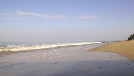 Tiro-De-ángulo-Bajo-Olas-Tropicales-Y-Hombre-Trotando-A-Lo-Largo-De-La-Playa,-Carrera-Temprano-En-La-Mañana