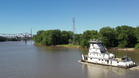 boat sailing down the river with a bridge in the background