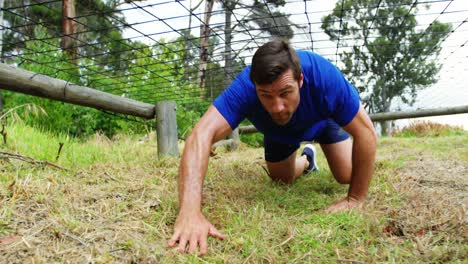 Fit-man-crawling-under-the-net-during-obstacle-course-4k