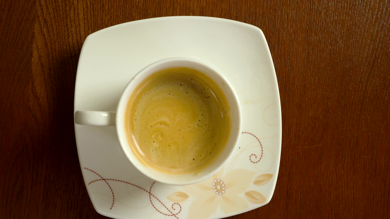 una taza de café de cerca. el hombre con la mano agita el café con la cuchara de té. vista superior de cerca cerrada.