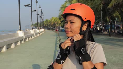 portrait of an active asian woman wearing protective helmet for inline skating safety in thailand