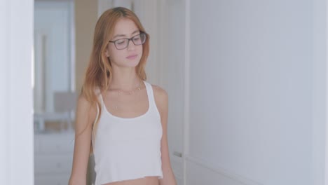 young alluring lady walking in hall of apartment