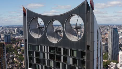 close up footage of propellers of wind turbines integrated into skyscraper design. ecology and sustainable energy resources. london, uk