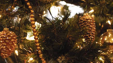 close up of ornaments and decorations on a christmas tree - slow motion tilt down