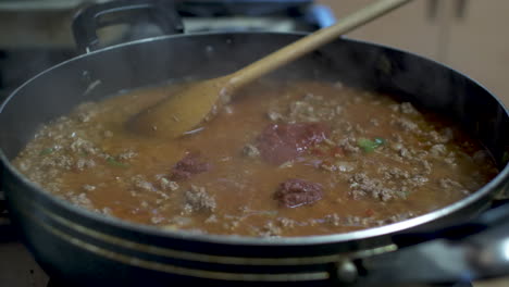 tomato sauce paste being added to sizzling mince meat