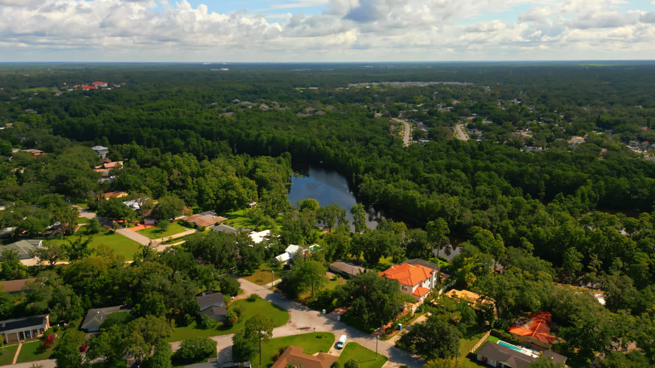 Slow drone flyover Tampa suburb neighborhood along the Hillsborough River on a beautiful day