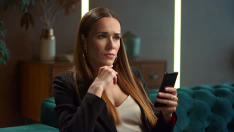 Businesswoman-using-smartphone-in-modern-interior.-Worker-looking-at-cellphone