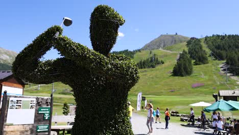 topiary sculpture with mountain backdrop and visitors