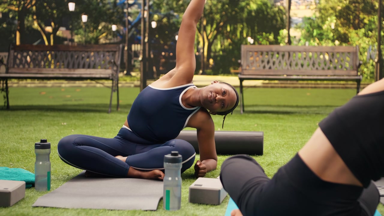 Young participants perform synchronized seated side bend with arms overhead