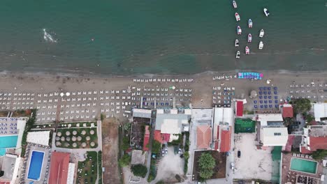 vista aérea de arriba hacia abajo de la playa de laganas, la isla de zakynthos, grecia, sombrillas y edificios frente al mar