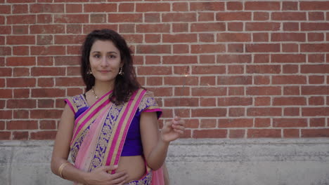 portrait of beautiful girl holding sparkler to celebrate diwali