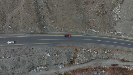 Toma-En-ángulo-Superior-De-Vehículos-Locales-Circulando-Por-La-Carretera-Gilgit-En-Pakistán