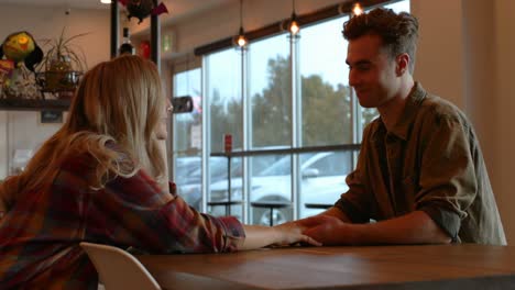 Pareja-Joven-Interactuando-Entre-Sí-En-La-Cafetería-4k