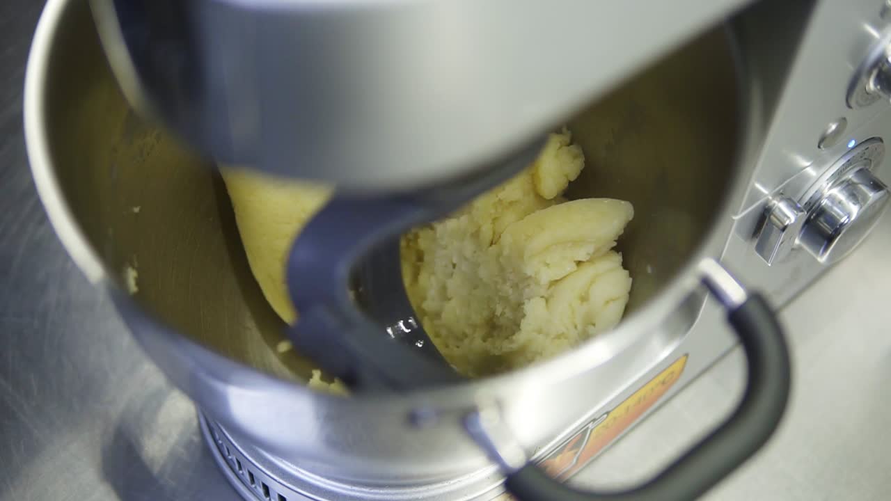 todos los ingredientes necesarios para la masa elaborada se mezclan en la máquina mezcladora. preparación de la masa para deliciosos eclaires o profiteroles. postres franceses tradicionales.