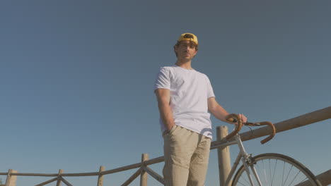 ciclista masculino en un paseo marítimo mirando a la cámara
