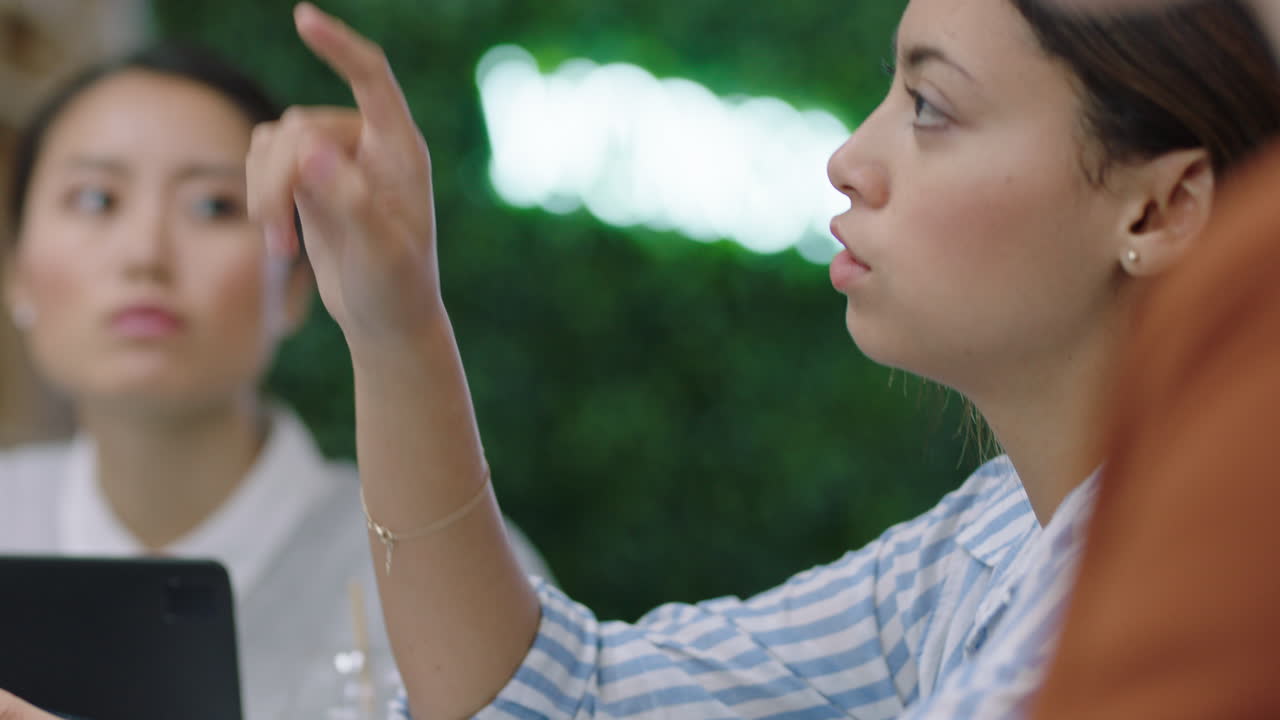 다민족 사업가들이 히스패닉 팀 리더를 만나 아이디어를 공유하고 사무실 관리 교육 프레젠테이션에서 기업 마케팅 전략에 의문을 제기합니다.