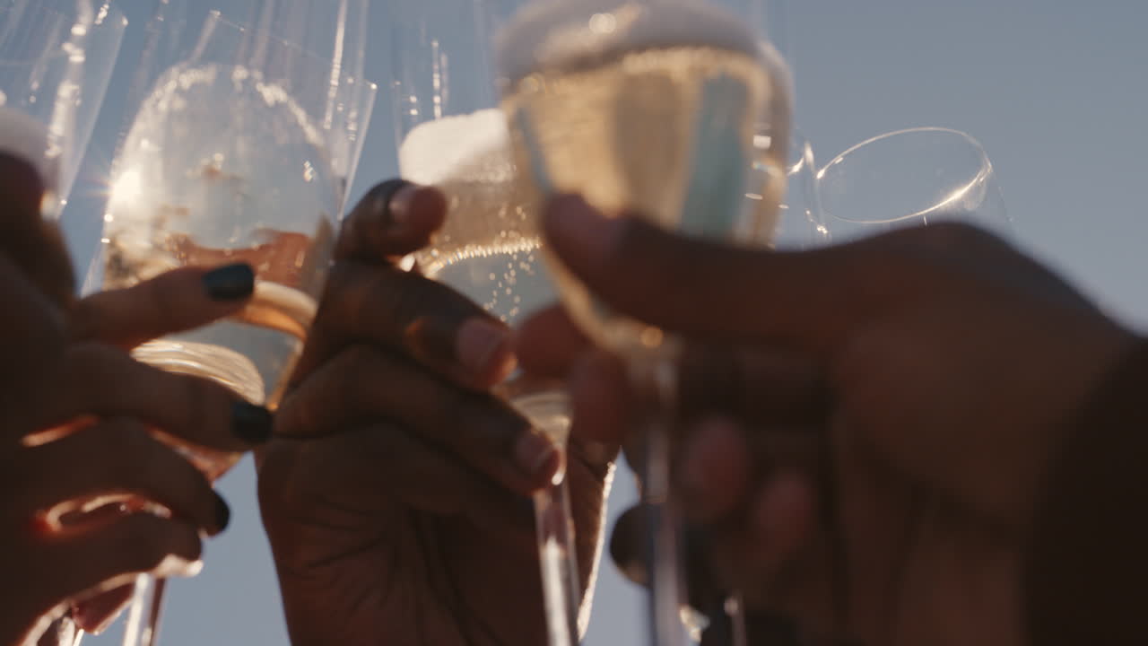 close up happy group of friends making toast drinking champagne celebrating rooftop party enjoying diverse reunion celebration on weekend social gathering at sunset