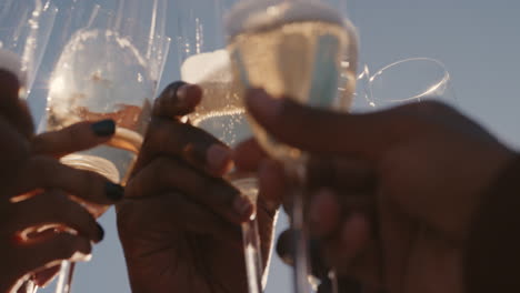 nahaufnahme einer glücklichen gruppe von freunden, die toast machen, champagner trinken, eine party auf dem dach feiern und am wochenende ein geselliges beisammensein bei sonnenuntergang genießen