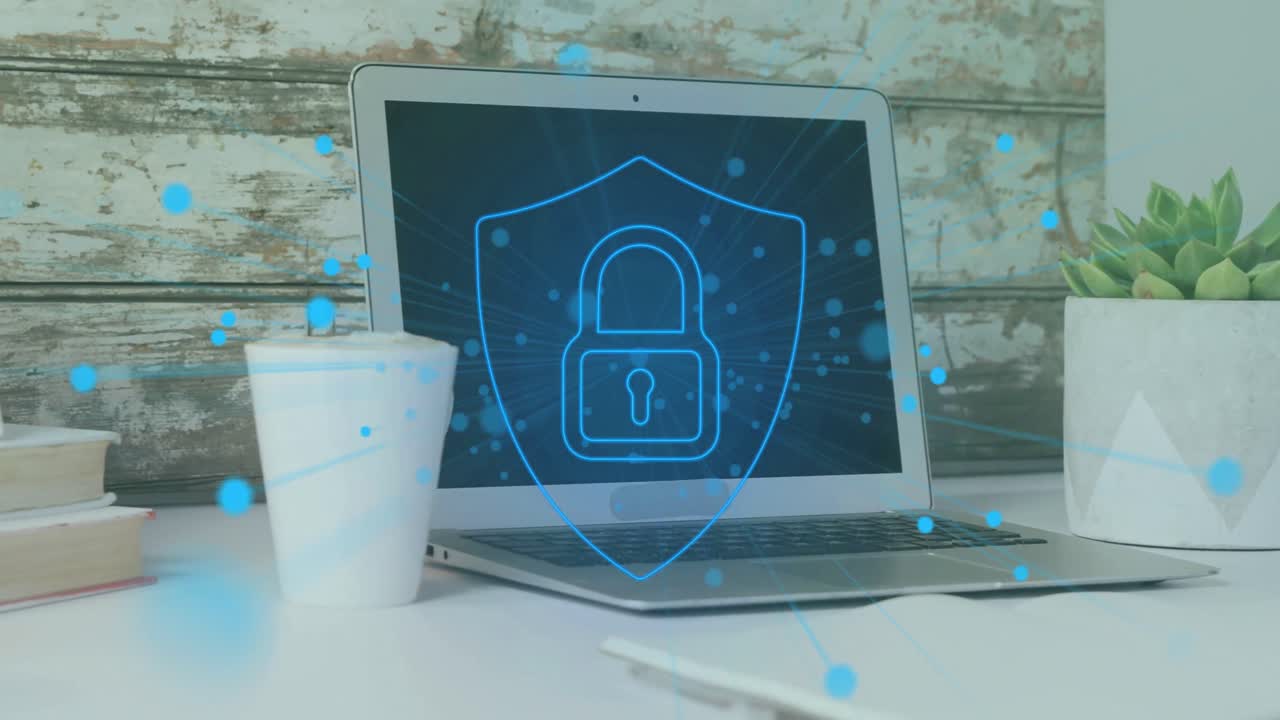 animación de puntos alrededor del candado en el escudo sobre la taza de café y la computadora portátil en el escritorio en la oficina