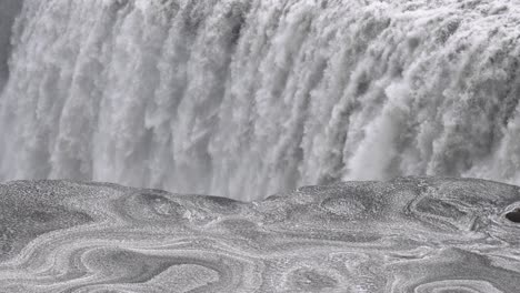 Mächtiger-Dettifoss-Wasserfall-In-Nahaufnahme,-Island,-Schneemuster-Im-Vordergrund