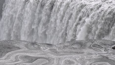 powerful dettifoss waterfall in closeup, iceland, snow pattern in foreground