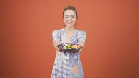 la persona que sostiene un plato de ensalada se está riendo.