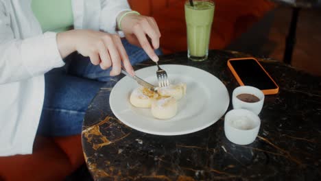 una mujer comiendo postre en un café.