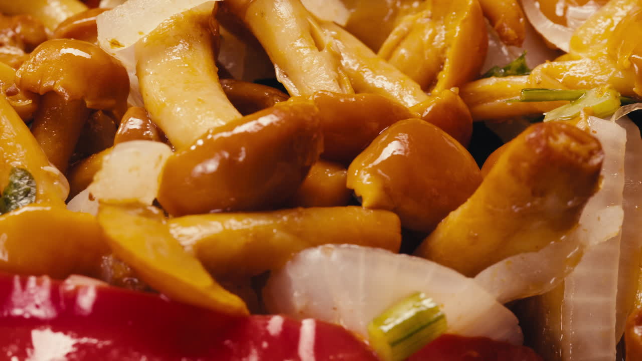Close-up of fermented yellow honeydew mushrooms with onion on plate. Preservation of vegetables in glass jars. Fermentation preserved mushroom with spices rotating macro.