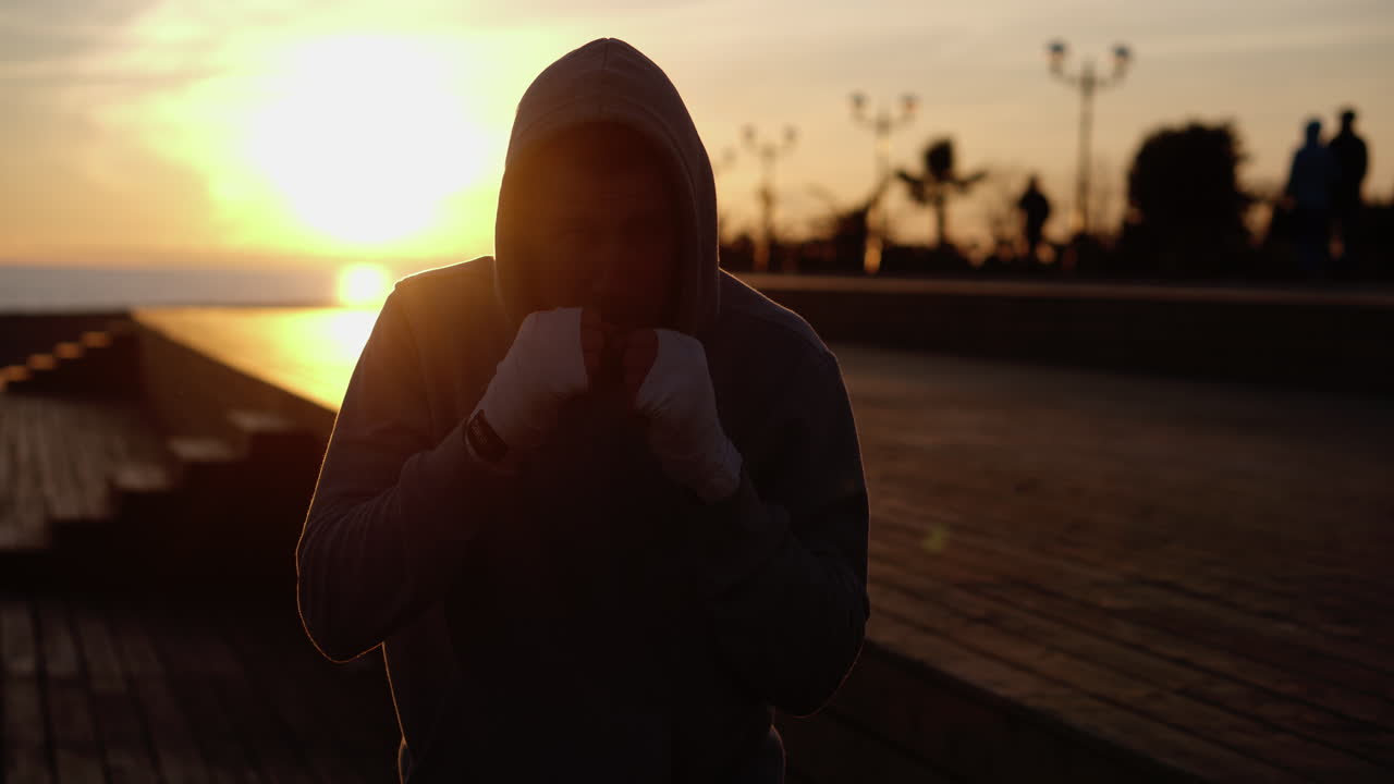 Silhouette di un pugile che si allena al tramonto