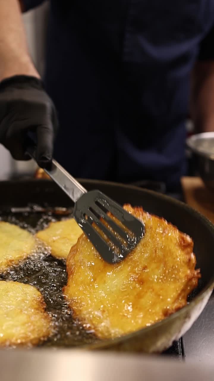 Chef che frigge frittelle di patate dorate nell'olio caldo in padella