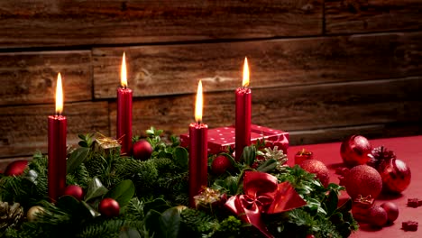 time lapse of four burning red candles on a advent wreath with festive decoration