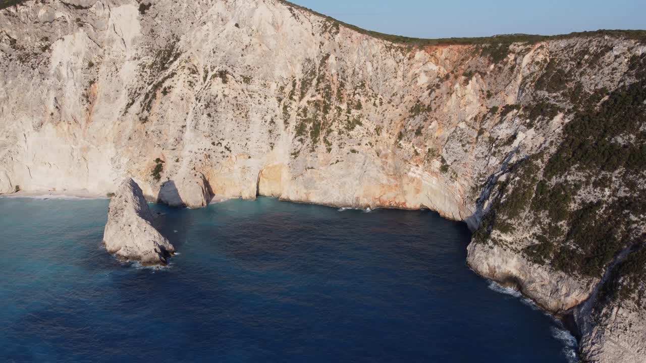 acantilado de la isla de la colina con agua de mar azul en lefkada, grecia - seguimiento aéreo de drones en un clima soleado