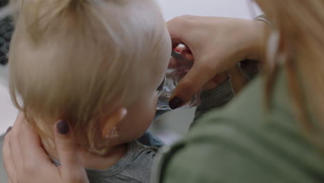 Cerrar-Joven-Mujer-De-Negocios-Caucásica-Madre-Alimentando-Al-Bebé-Agua-Potable-Mamá-Feliz-Mostrando-Afecto-Cuidando-A-Un-Niño-Pequeño-En-Una-Reunión-De-Oficina