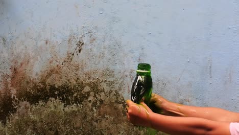 apriete con la mano la botella llena de líquido verde hasta que salga a cámara lenta