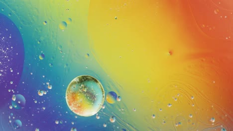 Animation-of-bubbles-moving-on-blue,-yellow-and-orange-liquid-with-copy-space