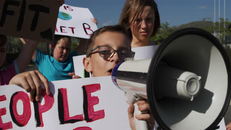 Gruppe-Von-Kindern-Mit-Schildern-Zum-Klimawandel-Und-Megafon-Bei-Einer-Protestkundgebung