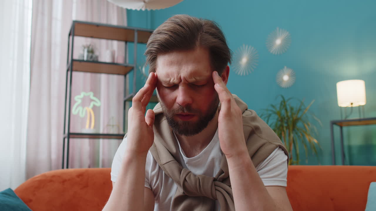 Displeased caucasian man rubbing temples to cure headache problem suffering from migraine stress