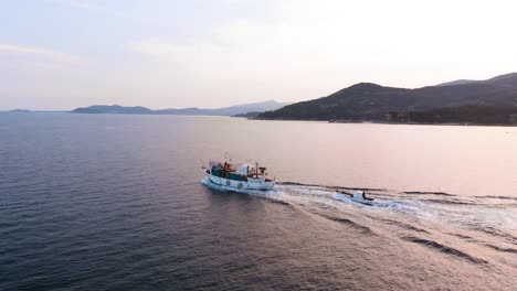 Aerial-Panning-Shot-of-Wooden-Fishing-Boat-Cruising