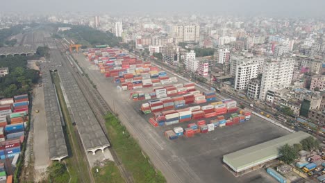 aerial ascending view ship containers terminal near railroad station, dhaka