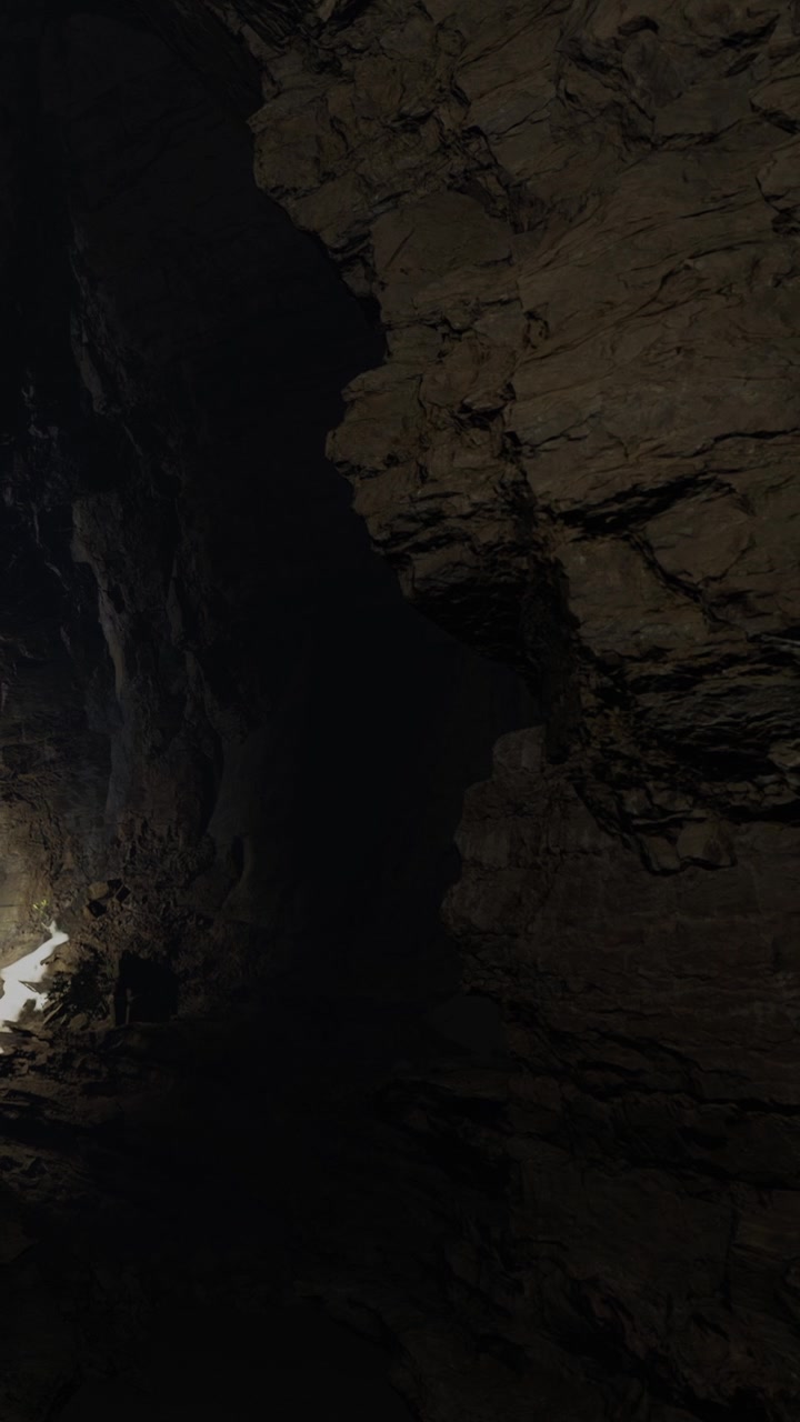 Esplorando una grotta buia con la luce che illumina le pareti rocciose e il pavimento