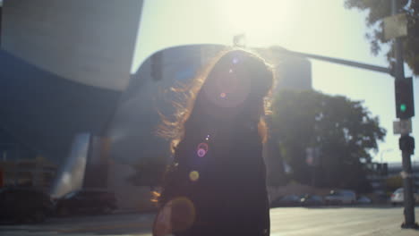 back view woman walking on bright sunlight. asian girl cross road on green light