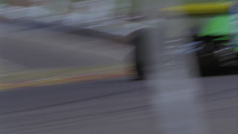 a racing car races by as people sit on the grass