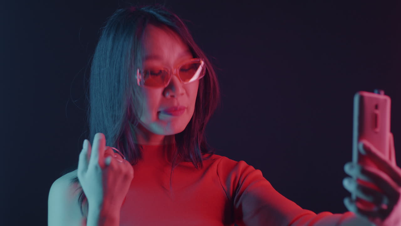 Donna alla moda che si scatta un selfie alla luce al neon