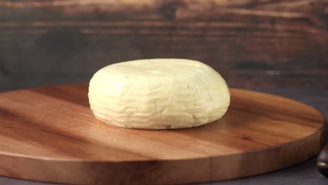 round shape cheese on chopping board on table