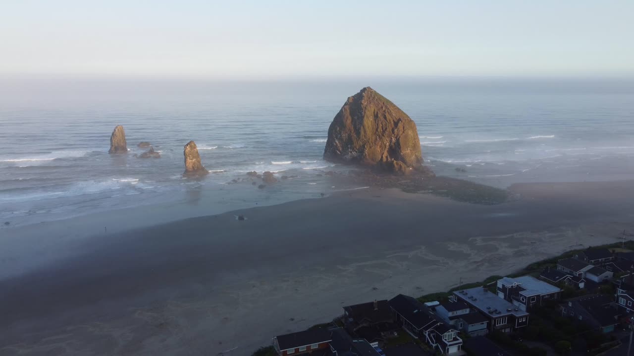 4K 30FPS Aerial Drone Footage of Beautiful Sunrise on the Oregon Coast - Mossy Haystack Rock and Crystal Clear Blue Water Crashing Against the Pacific Ocean Coast, Sea birds flying - Panning Up Shot