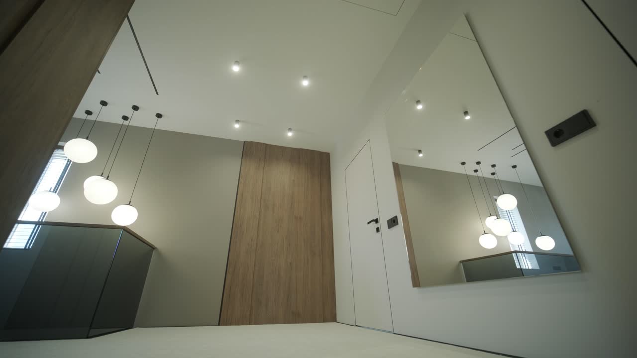 pasillo moderno con iluminación colgante y paneles de madera